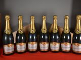 six bottles of champagne lined up in a row on a table
