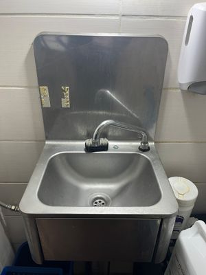 un lavabo dans un coin d'une petite salle de bains
