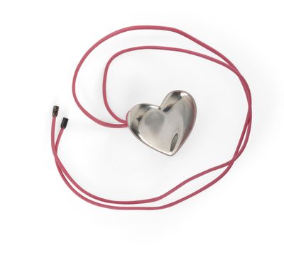 pendentif en argent en forme de cœur avec un cordon rouge sur fond blanc