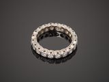 a white gold and diamond ring on a black surface