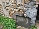 un vieux téléviseur posé par terre à côté d'un mur de pierre