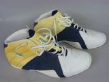 pair of yellow and blue sneakers with white laces on a gray surface
