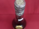 une bouteille de vin posée sur une surface rouge