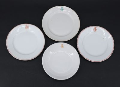 quatre assiettes blanches ornées de bordures dorées et de motifs floraux