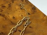 gold plated paper clip and chain necklace on a wooden board