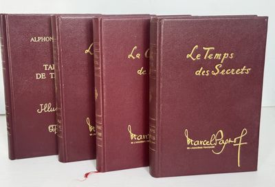 trois livres rouges ornés d'inscriptions dorées, posés sur une table