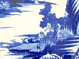 a blue and white plate with a painting on it