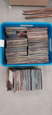 a blue container full of cds and other records