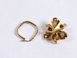 two pieces of gold colored jewelry on a white surface