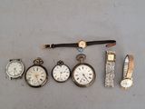 cinq types de montres différents et une montre posée sur une table