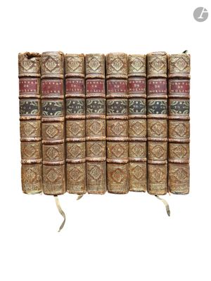 Les vieux livres sont alignés en rangées sur une surface blanche.
