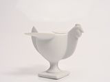 a white bowl with a chicken on it on a white surface