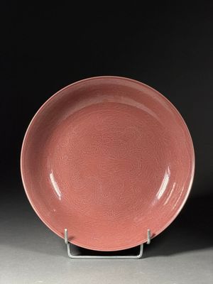 an image of a pink plate on a stand against a black background