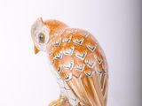 a figurine of an owl sitting on top of a table