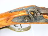 an old rifle with a wooden barrel and metal fittings