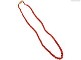 gros plan d'un collier de perles rouges sur fond blanc
