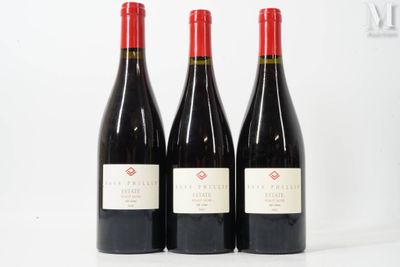trois bouteilles de vin rouge posées sur une table blanche