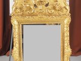 un miroir posé sur un pied, avec un rideau rouge en arrière-plan