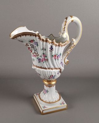 un vase blanc et doré orné d'un motif floral