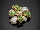 une broche en forme de fleur, sertie d'émeraudes et de diamants