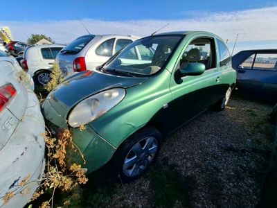 une petite voiture verte garée sur un parking avec d'autres voitures
