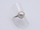 sterling silver ring with a white pearl on a clear acrylic surface