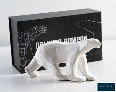 une figurine d'ours polaire blanc devant une boîte noire
