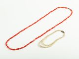 a red and white necklace and a gold chain on a white background
