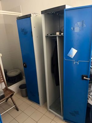 plusieurs casiers bleus dans une pièce où se trouvent une chaise et une chaise