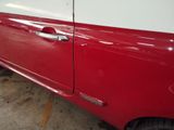 a red and white van parked in a parking lot
