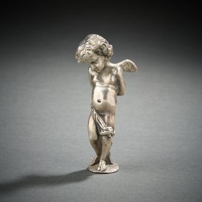 une figurine ancienne en argent représentant un garçon tenant un oiseau