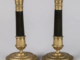 une paire de bougeoirs noirs et dorés sur fond blanc