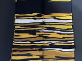 a yellow and black striped scarf hanging on a wall