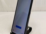 a close up of a phone on a stand on a white surface