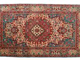 un tapis rouge et bleu orné d'un motif en médaillon sur fond blanc