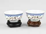 pair of chinese porcelain bowls on wooden stand on white background