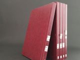 three red binders stacked on top of each other on a gray surface