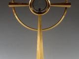 une image représentant une sculpture dorée représentant un objet circulaire posé sur un socle