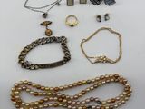 a group of assorted jewelry including a necklace, bracelet, and broocher