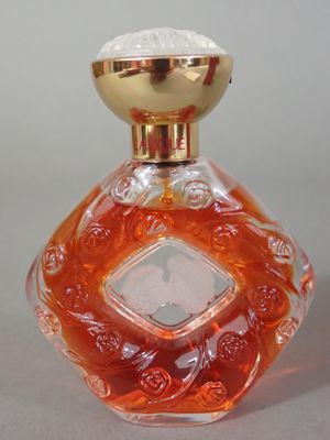 une bouteille en verre orange avec un bouchon doré, posée sur une table