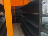 many empty shelves in a store with water bottles on them