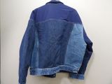 blue jean jacket hanging on a hanger on a wall