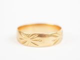 gros plan d'une bague en or sur une surface blanche