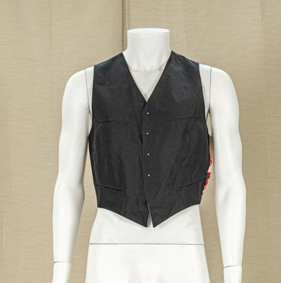 a mannequin wearing a black vest with red patches on it