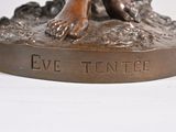 a bronze statue of a dog with a ball in its mouth