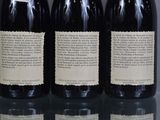 three bottles of wine are lined up on a glass table
