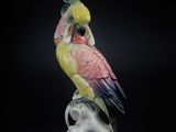 a figurine of a parrot sitting on top of a branch