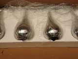 four silver spoons in a box wrapped in plastic wrap