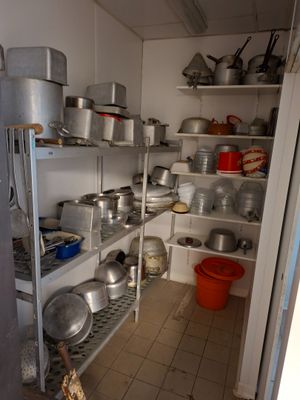 de nombreuses casseroles et poêles sur les étagères de la cuisine
