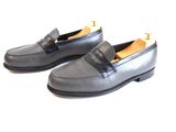 men ' s black leather loafers with gold accents on the toe